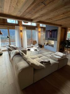 ein Wohnzimmer mit einem großen Sofa in einem Haus in der Unterkunft CHALET UTOPIA in Saint-Gervais-les-Bains
