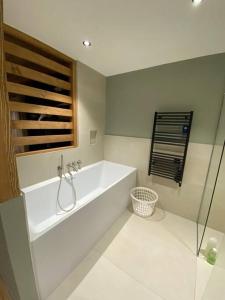 baño blanco con bañera y ducha acristalada en CHALET UTOPIA, en Saint-Gervais-les-Bains