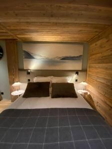 a bedroom with a large white bed with two pillows at CHALET UTOPIA in Saint-Gervais-les-Bains