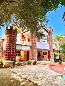 a large brick building with a tree in front of it at Casa el Capricho Cancún in Cancún