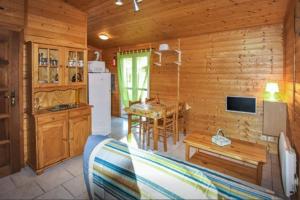 w domku z bali kuchnia i jadalnia ze stołem w obiekcie Le Clos Chantéric accueille jusquà 5 personnes w mieście Thueyts
