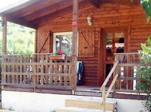 drewniany domek z werandą i drzwiami w obiekcie Le Clos Chantéric accueille jusquà 5 personnes w mieście Thueyts