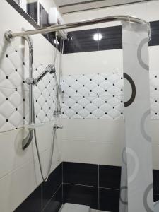 y baño con ducha y azulejos blancos y negros. en Apartment Near Republic Square Yerevan, en Ereván 2 fotos más