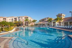 una piscina en un complejo con sillas y apartamentos en condominio en Deluxe 3 Bedroom Apartment 404 en Orlando