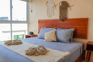 1 dormitorio con 1 cama azul y 2 toallas en Gama 09 Apartments, en Tulum