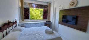 1 dormitorio con 2 camas y TV de pantalla plana en COGRA0100 - Muito verde pertinho do Shopping Barra, en Salvador