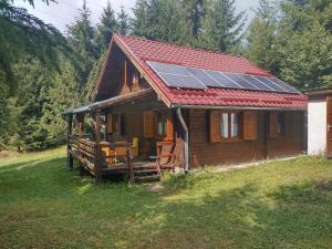 ein Haus mit Sonnenkollektoren auf dem Dach in der Unterkunft Cabana DUY-KAY in Lacul Roşu