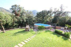a backyard with a swimming pool and a grass yard at Villa Capllonch in Banyalbufar