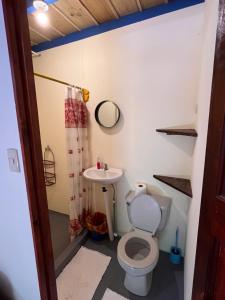 La salle de bains est pourvue de toilettes et d'un lavabo. dans l'établissement Hostel Tuanis Surf Camp, à Santa Teresa