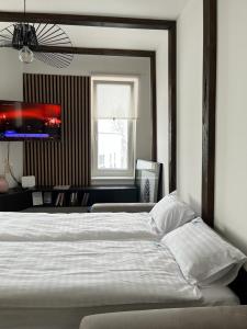 a bedroom with a large white bed and a tv at Randevu Nivalis in Jahorina +39 photos