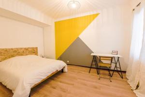 1 dormitorio con cama y escritorio. en charmant logement plein pied au cœur du village, en Castelculier