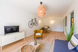 ein Wohnzimmer mit einem TV und einem Fahrrad an der Wand in der Unterkunft charmant logement plein pied au cœur du village in Castelculier