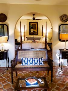 1 dormitorio con 1 cama y un banco en una habitación en Puertas en Vieques