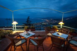 eine Terrasse mit einem Tisch und Stühlen auf dem Balkon in der Unterkunft Piccola Bomboniera Sul Mare in Borgio Verezzi
