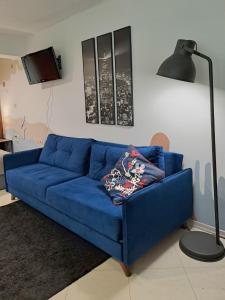 a blue couch in a living room with a lamp at Студио Цвят/ Studio Colour in Blagoevgrad