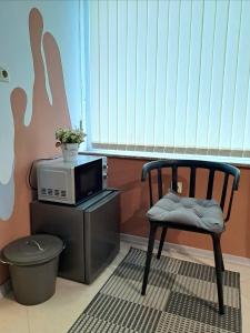 une chaise assise dans une pièce avec un four micro-ondes dans l'établissement Студио Цвят/ Studio Colour, à Blagoevgrad