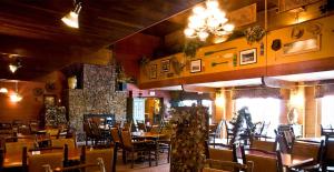 un ristorante con tavoli, sedie e un camino di The Lodge at Wisp a McHenry