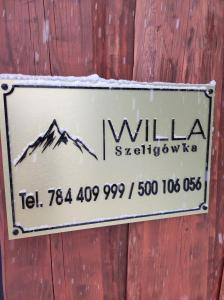 un panneau sur un mur en bois avec une montagne sur celui-ci dans l'établissement WILLA SZELIGÓWKA KOŚCIELISKO, à Kościelisko