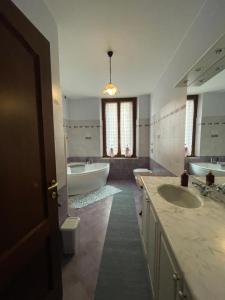 uma grande casa de banho com 2 lavatórios e uma banheira e um tubermott em B&B In Liberty Style em Settimo Milanese