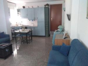 ein Wohnzimmer mit einem blauen Sofa und einer Küche in der Unterkunft Piccola Bomboniera Sul Mare in Borgio Verezzi