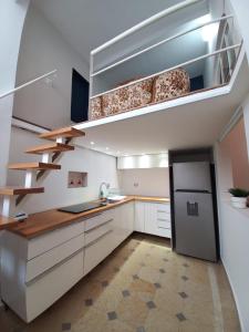 una cocina con armarios blancos, lavamanos y escaleras en Casa Turin, en Ciudad de México