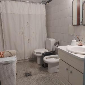 a bathroom with a toilet and a shower curtain at La Glicina casa in La Plata