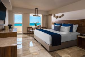 Un dormitorio con una cama y vista al mar. en Dreams Sands Cancun Resort & Spa, en Cancún