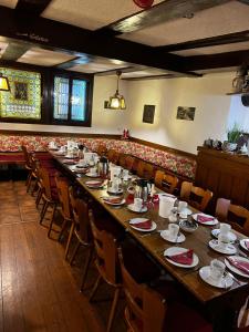 a long long table in a restaurant with chairs and tables at Gaststätte Braustübchen in Schlitz
