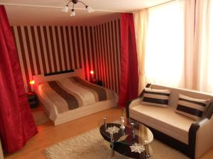 een woonkamer met een bed en een bank bij Guest House Tsenovi in Koprivshtitsa