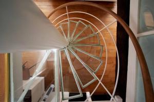 eine Wendeltreppe in einem Zimmer mit Holzdecke in der Unterkunft Duplex de charme avec terrasse aux portes de Paris in Saint-Germain-en-Laye