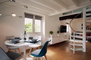 ein Esszimmer mit einem Tisch und Stühlen sowie ein Schlafzimmer in der Unterkunft Duplex de charme avec terrasse aux portes de Paris in Saint-Germain-en-Laye