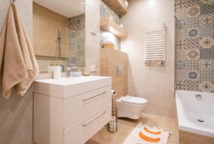 a bathroom with a white sink and a toilet at Love Live Łódź z ogrodem in Łódź