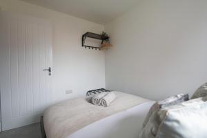 2 camas en un dormitorio con paredes blancas en StayRight 4 Bedroom, 3 Bathroom House Near M4 - 15 mins to Cardiff & Newport, en Cardiff