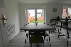a dining room with a table and some chairs at StayRight 4 Bedroom, 3 Bathroom House Near M4 - 15 mins to Cardiff & Newport in Cardiff