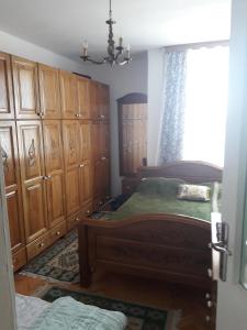 a bedroom with a bed and wooden cabinets and a window at Apartman Mihajlovic in Bijeljina
