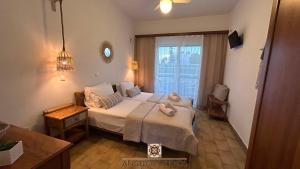 a bedroom with a bed and a large window at Angelos Studios No 3-4 in Faliraki