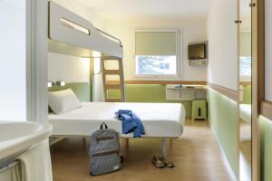 a room with a bed and a sink and a mirror at ibis budget Brugge Centrum Station in Bruges