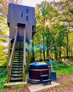 um parque infantil com uma escada e um barril em L'étape en forêt em Saint-Sever-Calvados