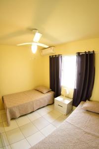 a bedroom with two beds and a window at Beto Carreiro - Praia - Relaxar à beira da piscina ou prepara algo na churrasqueira - Aproveite o seu tempo livre com a família e amigos em nosso espaço in Piçarras