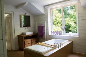uma casa de banho com um lavatório e uma janela em Villa Carpay em Louveigné