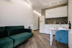 a living room with a green couch and a kitchen at Villa In Bed in Naples +57 photos