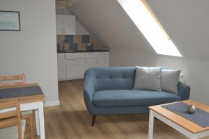 a living room with a blue couch and a table at Haus Simone in Insel Poel