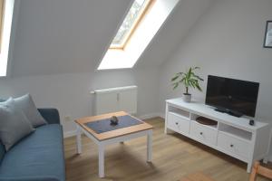 a living room with a couch and a tv and a table at Haus Simone in Insel Poel