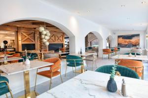 ein Esszimmer mit Tischen und Stühlen in der Unterkunft Das Kronberg Hotel - Adults Only - inkl Soft- und Heißgetränkeflat in Bodenmais