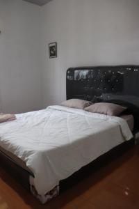 łóżko z czarnym zagłówkiem w sypialni w obiekcie HW. Hubers Hotel, Bar & Resto w mieście Laguboti