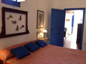 a bedroom with a bed with blue pillows on it at Baglio Del Piffero in Favignana