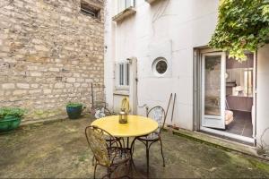 a patio with a table and chairs in front of a building at apartment with garden in Neuilly-sur-Seine