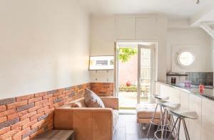 a living room with a couch and a brick wall at apartment with garden in Neuilly-sur-Seine