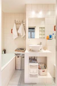a white bathroom with a sink and a tub at apartment with garden in Neuilly-sur-Seine