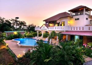 Amphoe KumphawapiBua Daeng Homestay Resort的一栋前面有游泳池的房子